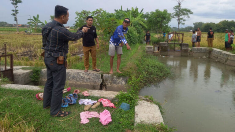 Petugas kepolisian sedang melakukan olah TKP, di tempat kedua bocah ditemukan tenggelam.