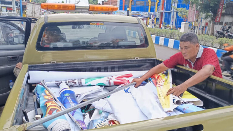 Satpol PP terlihat sedang menetibkan baliho dan banner yang sudah habis masa berlakunya dan ilegal. (Gema Surya/Yudi)