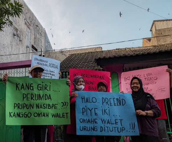 Warga bentangkan poster tuntutan agar rumah yang dijadikan sarang burung walet ditutup. (Dok. Gema Surya)