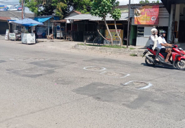 Salah satu diantara beberapa lubang yang mengaga, ditandai pilox oleh warga. (Foto/Feri)